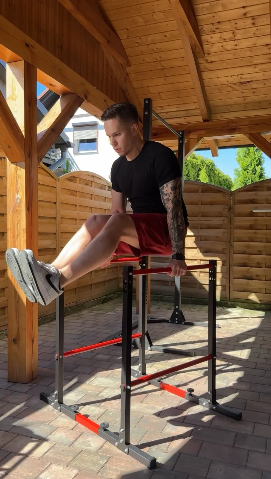 Trener Adrian Domagalski (95 kg) wykonuje ciężkie dipy z podwieszonym ciężarem 40 kg na poręczach K-Sport KSH025. Widoczna zamontowana dolna poprzeczka stabilizująca.