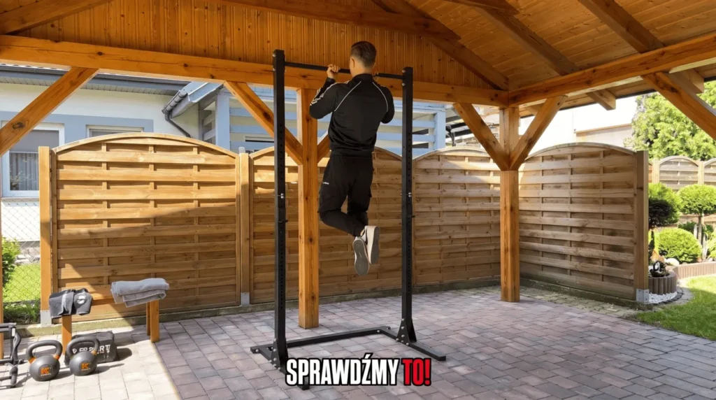 Trener Adrian Domagalski (95 kg) wykonuje test stabilności drążka na stojakach K-Sport KSG012 w domowej siłowni.