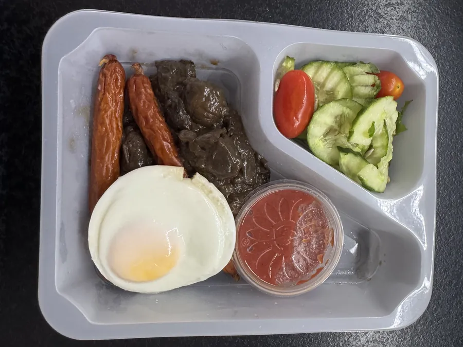Otwarte pudełko Robin Food: jajko sadzone, frankfurterki, pieczarki, sos pomidorowy i sałatka z ogórkiem i pomidorkami, bez pieczywa