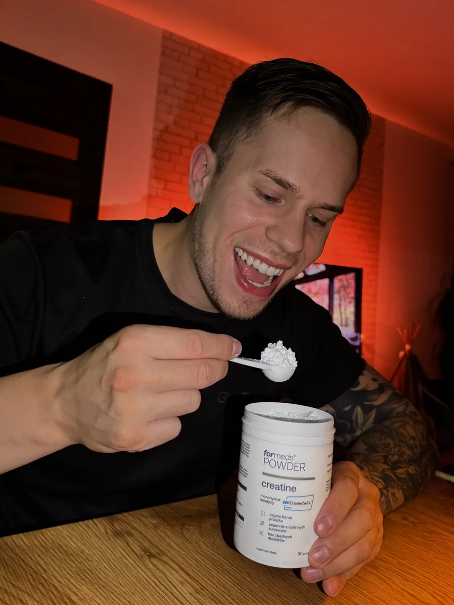 Adrian Domagalski odmierza miarką monohydrat kreatyny z otwartej puszki ForMeds POWDER creatine