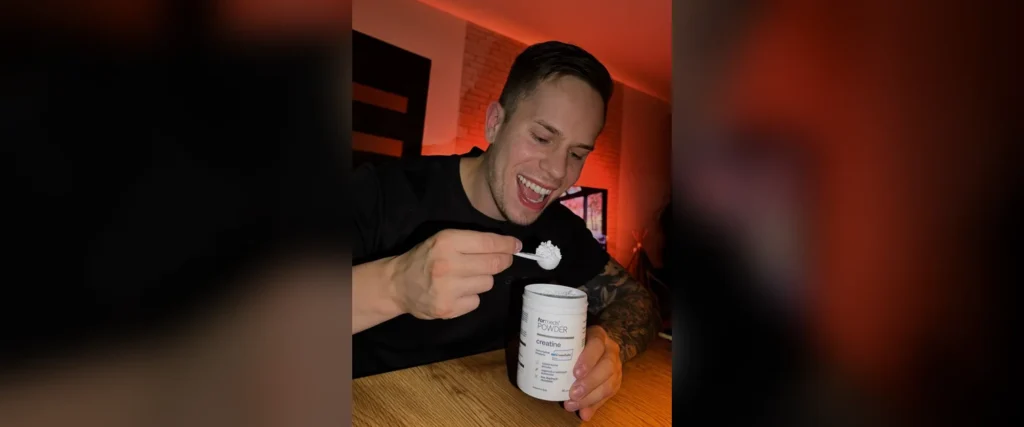 Adrian Domagalski z otwartą puszką kreatyny ForMeds POWDER creatine i miarką proszku